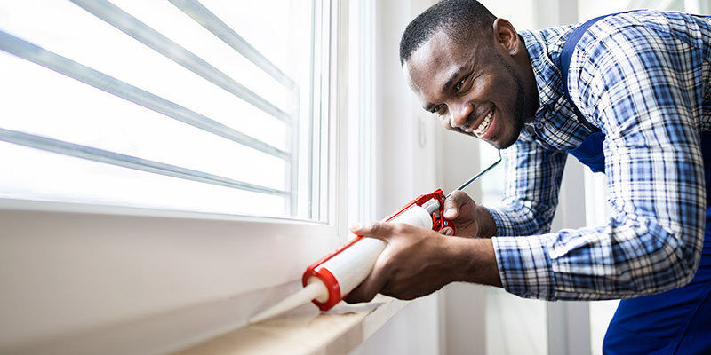 Man weatherproofing his home